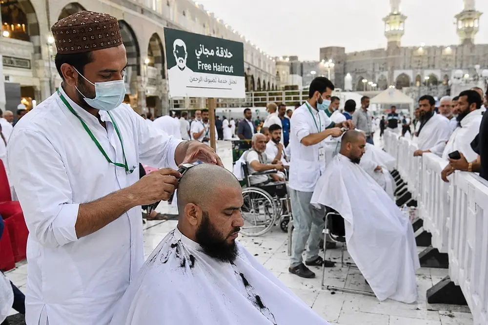 Jamaah umroh sedang menjalani proses tahallul dengan mencukur rambut di area Masjidil Haram, Makkah